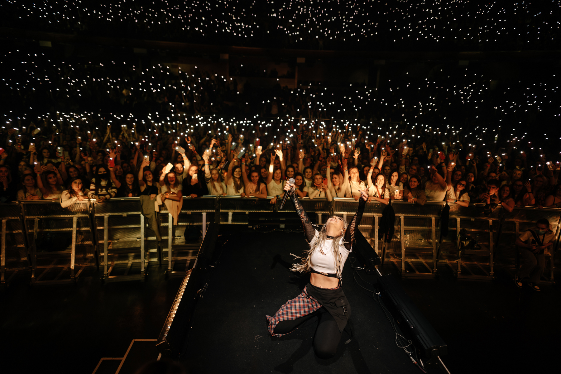 Rita Dakota performing on stage at concert with dramatic lighting and crowd